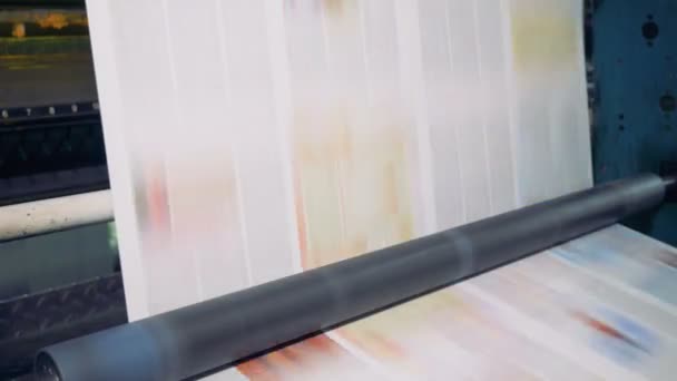 Des rouleaux spéciaux tournent pour déplacer le papier dans un bureau d'impression. 4K . — Video