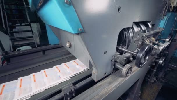 Tidningen flyttar på ett transportband på print kontor. Print house utrustning. — Stockvideo