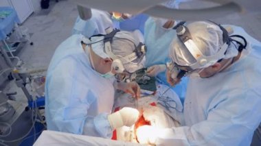 Cerrahlar takım çalışması modern bir klinikte, üstten görünüm.