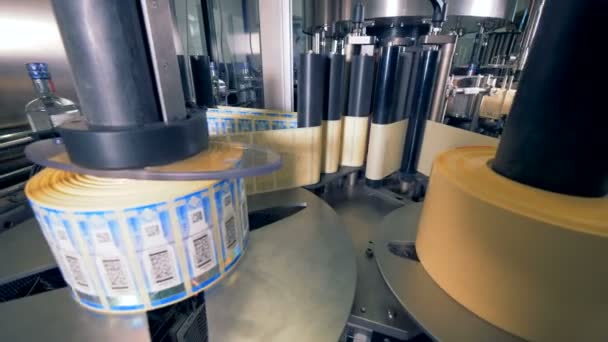 Rolls of tags for bottles. Special machine spins, putting tags on bottles at a plant. — Stock Video