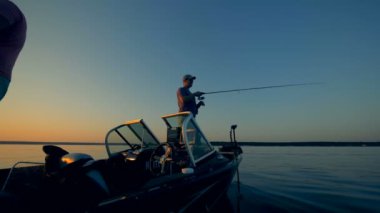 İki adam bir açık suda bir teknede Balık tutma