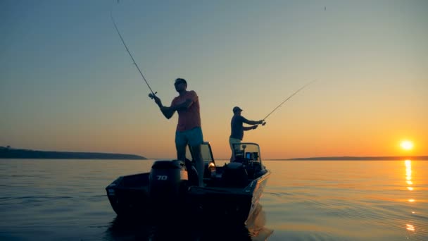 Мужчины ловят рыбу с моторки в открытом море — стоковое видео