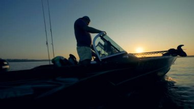 İki anglers balıkçılık Sunrise için bir autoboat sürüş