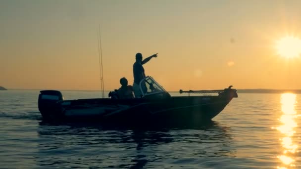 Východ slunce na šířku se dvěma muži, vybavené Rybářské plavby přes otevřené vodě — Stock video