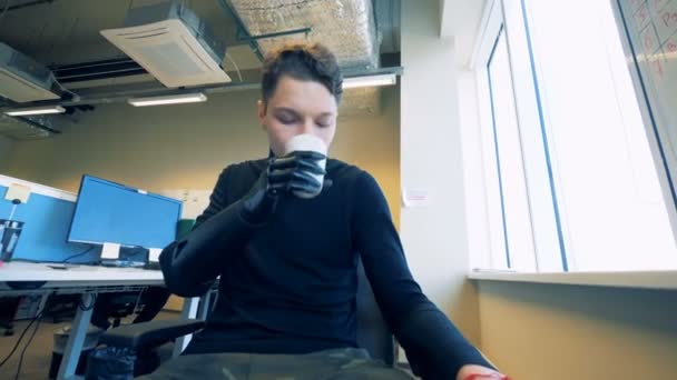 Handikappad man drinkar medan du håller en kopp med en bionic protes. Futuristiska koncept. — Stockvideo