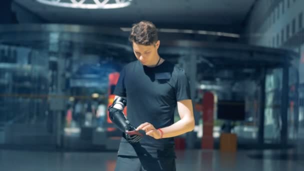 Jeden člověk drží telefon s jeho kybernetických protézy, pracovat s ním. Cyborg koncept. — Stock video