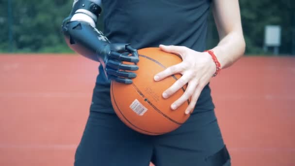 Mano biónica con una pelota, de cerca. Humano con un brazo robot . — Vídeos de Stock