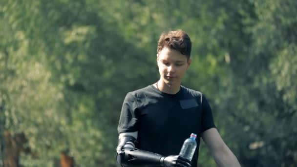 Proteshand håller en flaska. Människa med en robotarm. — Stockvideo