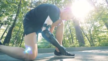 Özürlü kişi güneş arka planda, ayakkabılarını ipe yakın çekim.