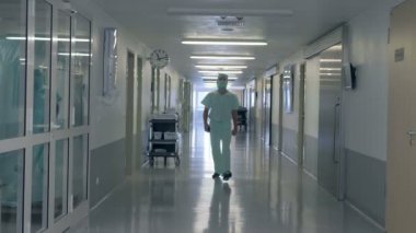 Yetişkin erkek doktor hastane hall tarafından geçiyor