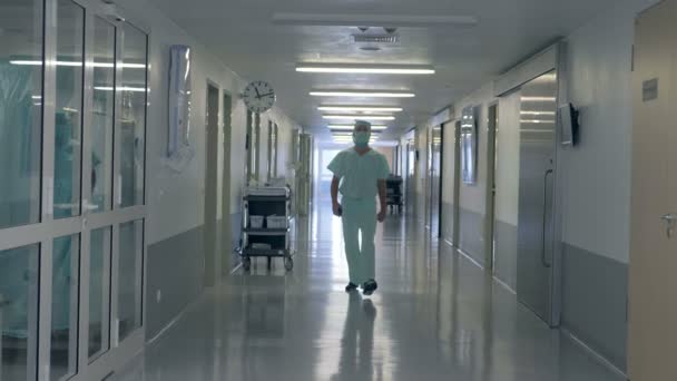 Дорослий чоловік-лікар проходить в лікарняному залі — стокове відео