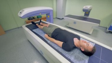 Yetişkin bir adam tarafından tıbbi bir makine taranır. X-ışını yordamı.