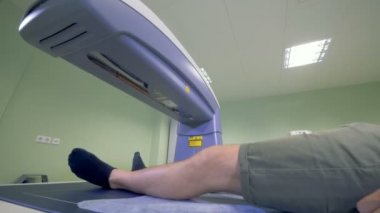 Erkek hastanın alt beden bir röntgen cihazı tarafından analiz edilir.