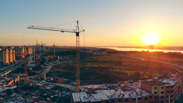 Egy építési terület szélén. Építési darukhoz naplemente háttér. — Stock videók