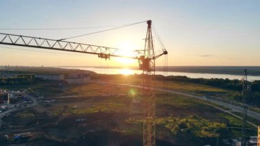 Vinç bir gün batımında sarı, yakın çekim. Bir inşaat sahasında Vinçler.