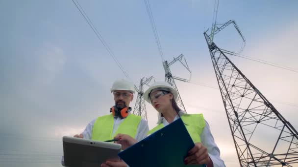 Eletricistas masculinos e femininos discutindo equipamentos elétricos . — Vídeo de Stock