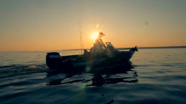 Dois pescadores estão à procura de um lugar para pescar enquanto navegam em uma lancha — Vídeo de Stock