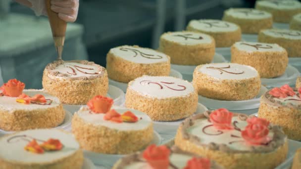 Un pastelero adorna pasteles, de cerca . — Vídeos de Stock