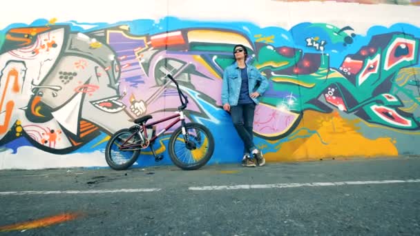 Retrato de un joven adolescente con una bicicleta BMX, vista inferior . — Vídeos de Stock