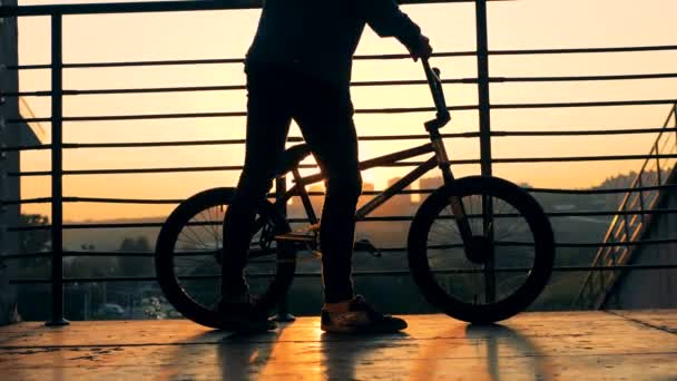 Ung man sitter på en cykel, närbild. — Stockvideo