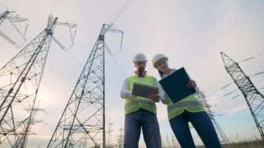 İki elektrikçiler birlikte, elektrik iletim hattı yakınındaki alanda çalışır. 4k.