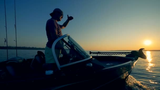Motorbåt får navigeras av två fiskare genom en sjö — Stockvideo