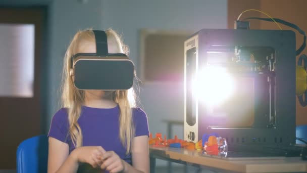 A girl is submerged into virtual reality by means of special glasses — Stock Video