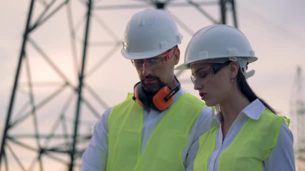Ingenieurs die werkzaam zijn in de buurt van transmissielijnen. 4k. — Stockvideo
