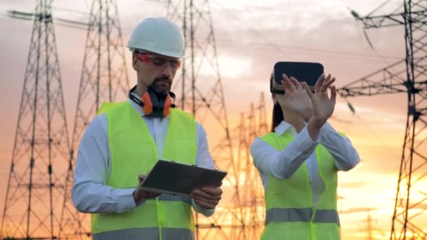 Ingénieurs utilisant des lunettes futuristes 3D VR près des lignes électriques. Concept de réalité augmentée . — Video