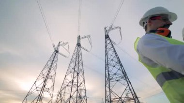 Elektrikçiler iş yerinde iletim hatları, alttan görünüm.