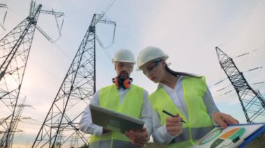 Elektrikçi ve foreman inşaat proje tablet üzerinde kontrol.