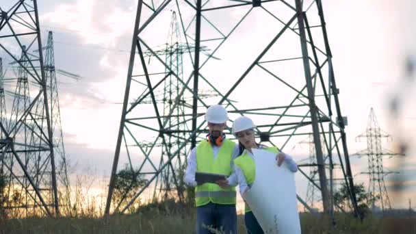 Travailleurs électriciens avec plan et tablette près du chantier de construction. 4K . — Video