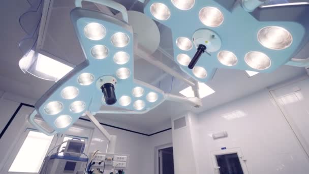 Utrustad operationssal med bord och två kirurgiska lampor — Stockvideo