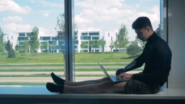 Mannelijke tiener met een bionische arm te typen op een laptop. Futuristische menselijke cyborg concept. — Stockvideo