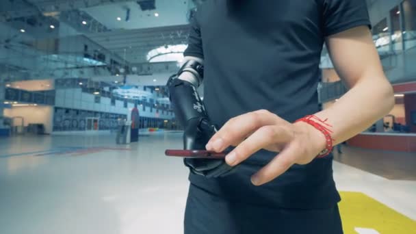 A man is holding a smartphone in his futuristic bionic prosthetic hand. Man of future concept. — Stock Video