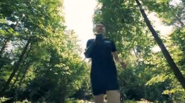 Bir futuristik biyonik protez kollu genç adam orman koşu