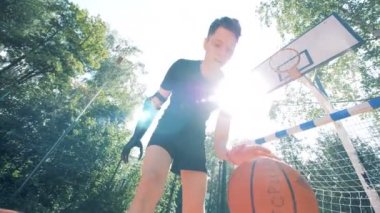 Basketbol oynarken bir biyonik protez kollu genç adam.