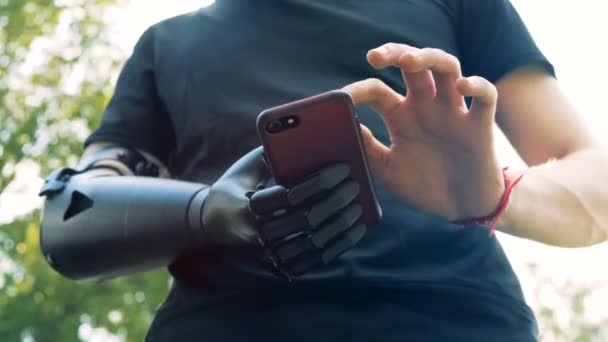 Hombre Yong con una mano artificial usando un teléfono inteligente. Concepto futuro . — Vídeos de Stock