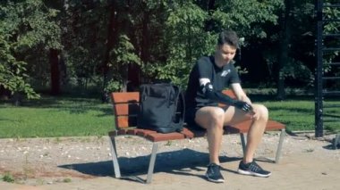 Genç bir biyonik el ile bir bankta oturan ve bir dizüstü bilgisayar üzerinde çalışmaya başlar. Gelecekteki kavramı.