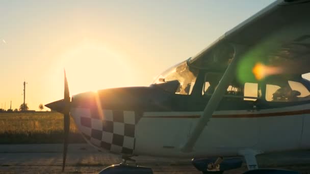 Avión privado ligero se mueve en una pista de despegue sobre un fondo de puesta de sol. 4K . — Vídeos de Stock