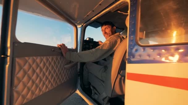 Der Pilot sitzt in einer Flugzeugkabine und schließt die Tür. 4k. — Stockvideo