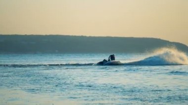 Bir binici sıçramalarına jet ski üzerinde yapar..
