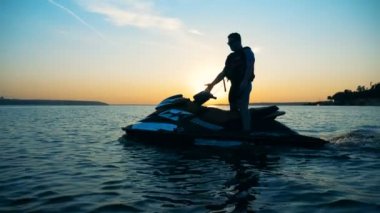 Jet ski günbatımı bir arka plan üzerinde sürme yakın çekim.