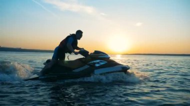 Erkek binici hızlı bir waverunner üzerinde yan görünüm gider.