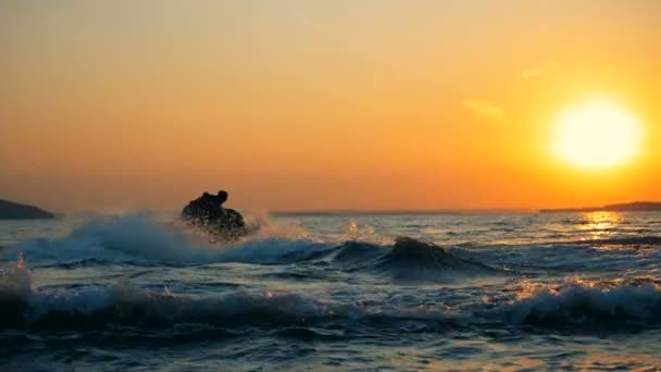 Persona che salta sulle onde su una moto d'acqua, vista posteriore . — Video Stock