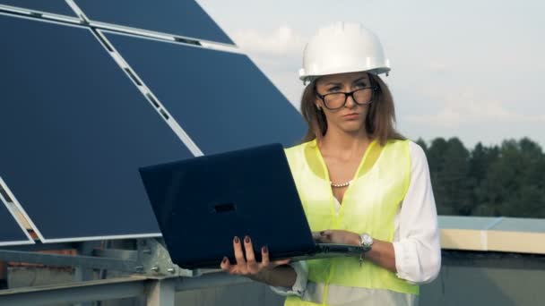 Napelemek, és egy női mérnök lesz mentén egy laptop. Alternatív energia koncepció. — Stock videók