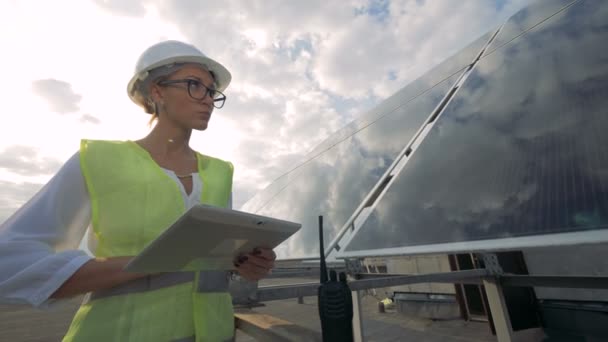 Inspetor solar feminino está trabalhando em seu computador enquanto está em pé nos telhados — Vídeo de Stock