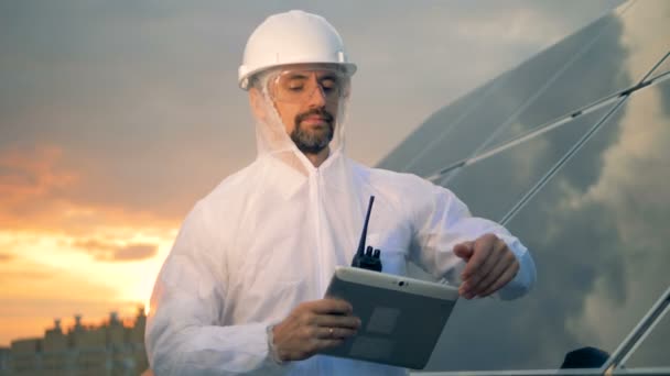 Lächelnder Solaringenieur justiert seine Brille und blickt direkt in die Kamera — Stockvideo