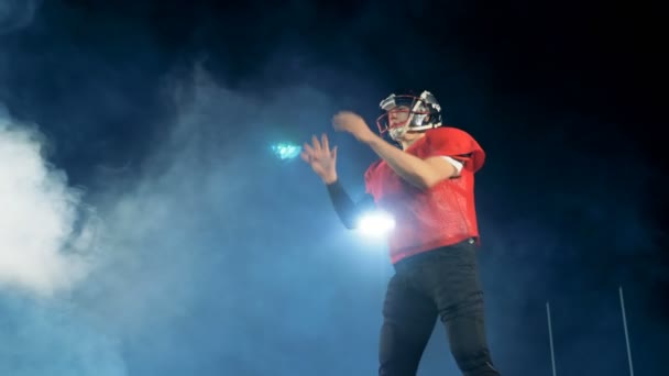 Joueur de football américain professionnel attrape un ballon tout en se tenant sur un terrain . — Video