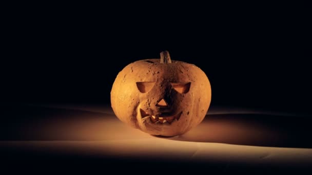 Zoom-in filmato di una zucca di Halloween con una candela in esso — Video Stock